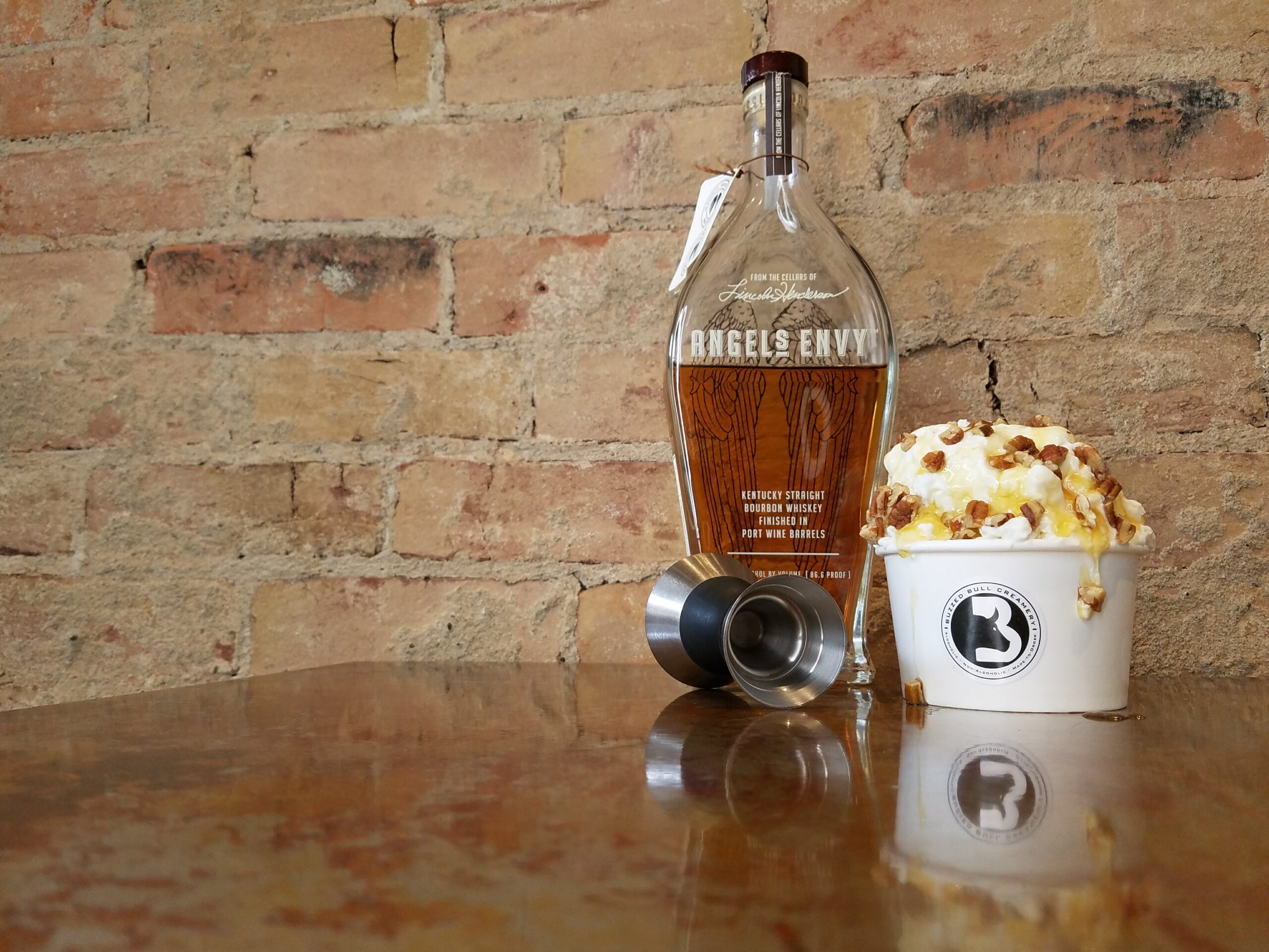 A cup of Buzzed Bull ice cream next to the liquor that was poured into it. 