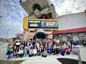 A field trip group from a middle school stands outside Beyond the Lens on the Parkway for a photo. 