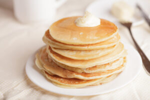 Stack of buttermilk pancakes topped with butter